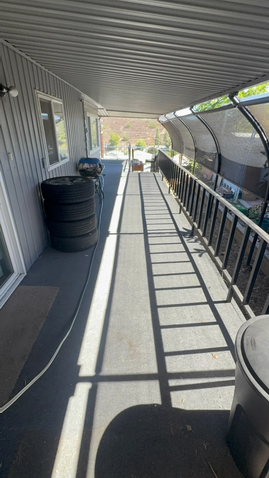 Cleared walkway on an El Cajon mobile home deck after junk removal, with some items remaining beside the home.