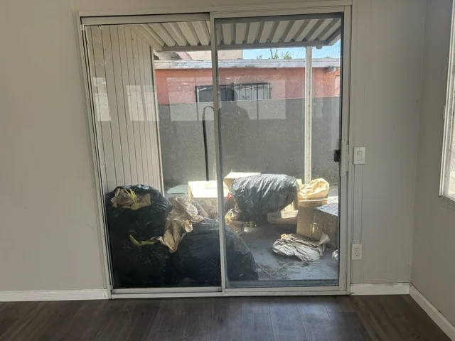 Bags, boxes, and loose items on a covered patio before a Chula Vista property cleanout.