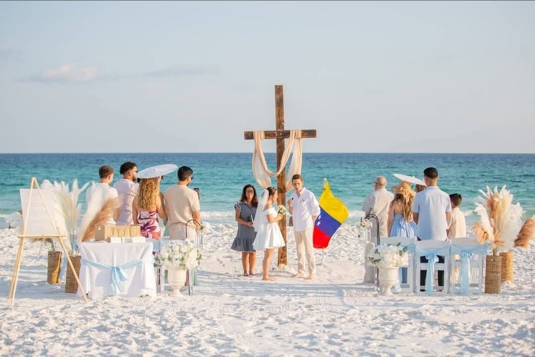 Bilingual seaside ceremony with wooden cross arch and family celebration on the Florida coast