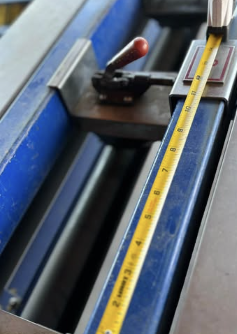 Measuring ductwork dimensions with tape measure during fabrication