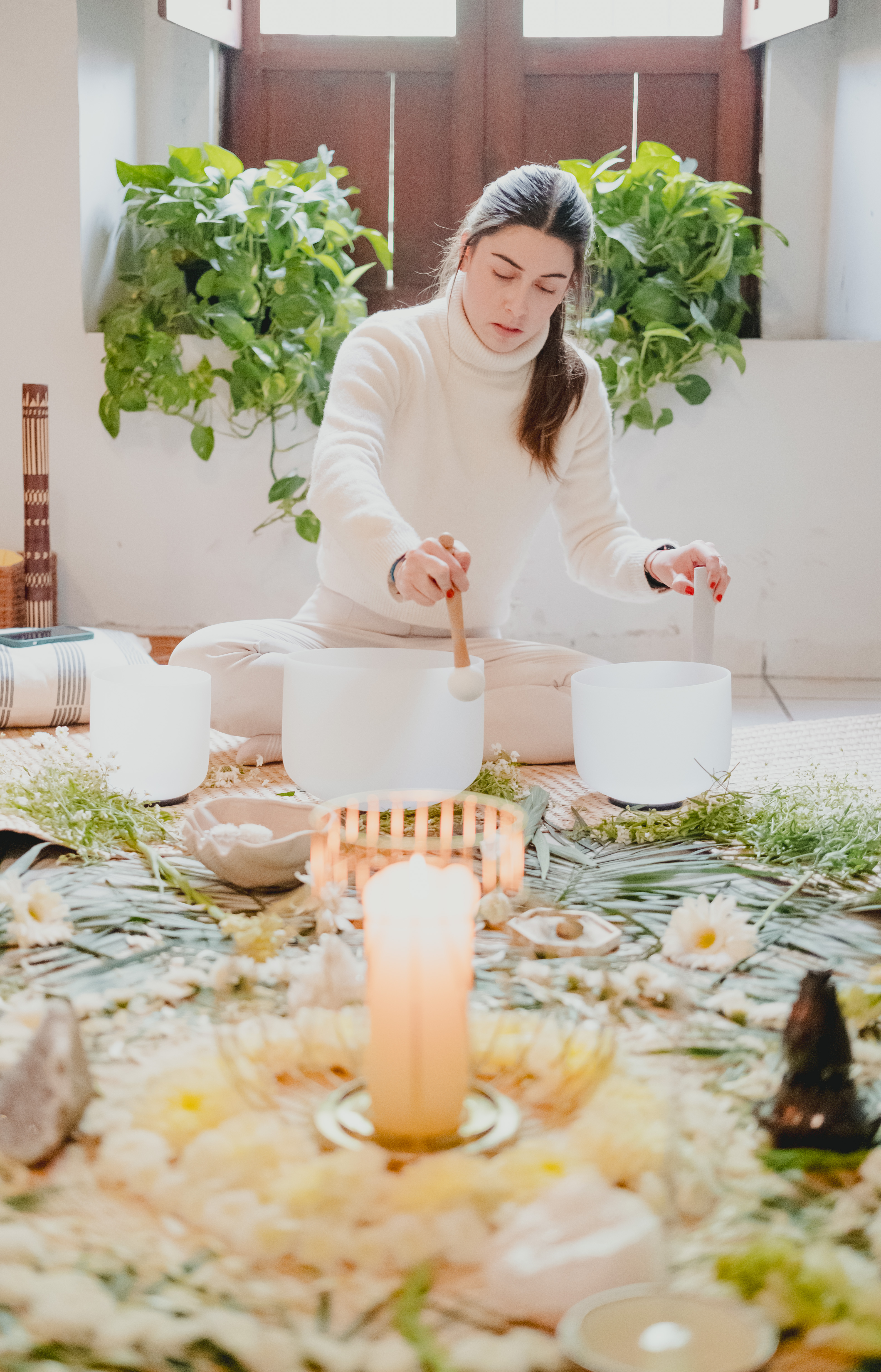 Facilitadora guiando con cuencos de cuarzo y velas