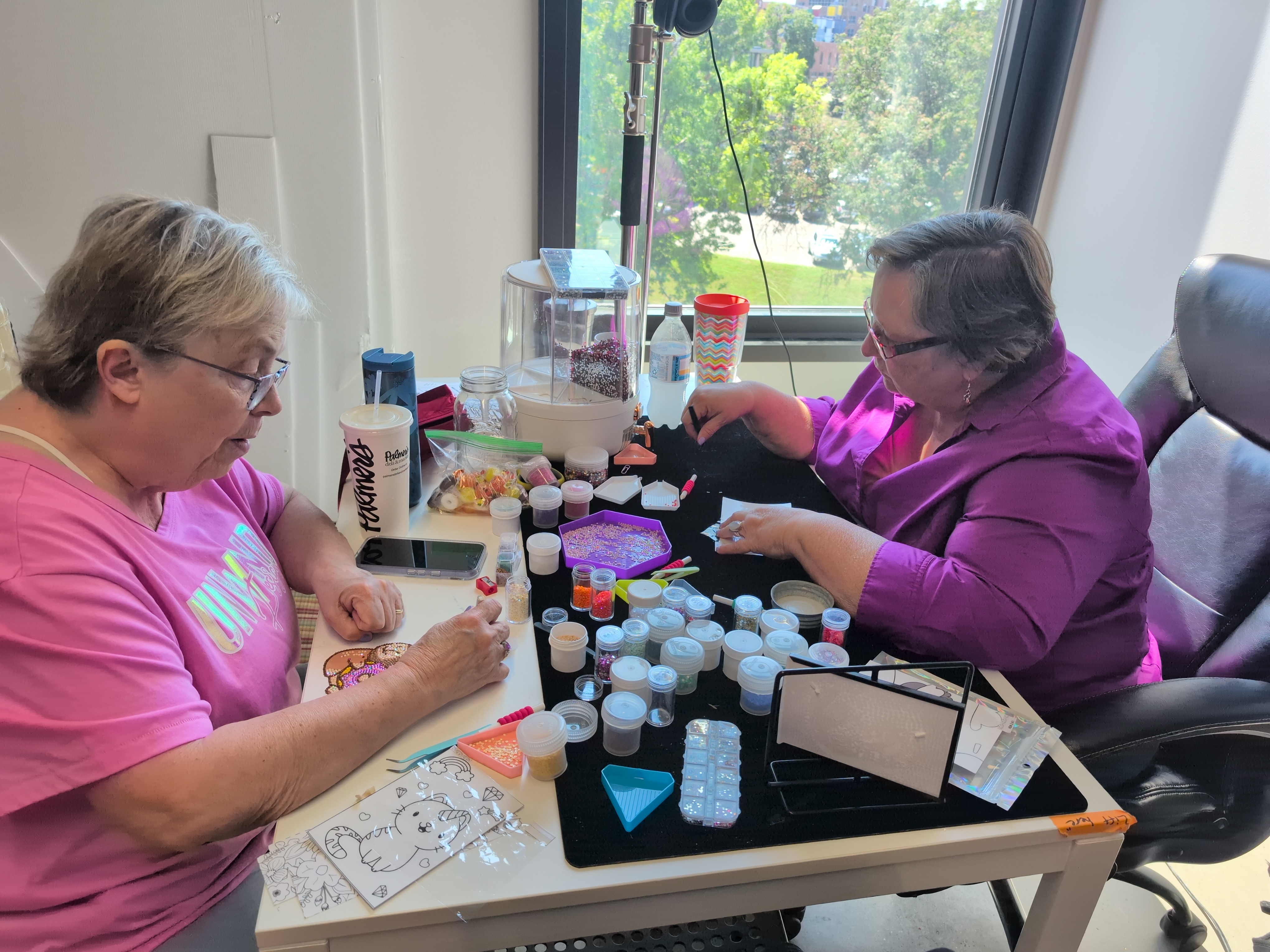 Happy crafter in a blue hoodie wearing her custom diamond painted heart sunglasses