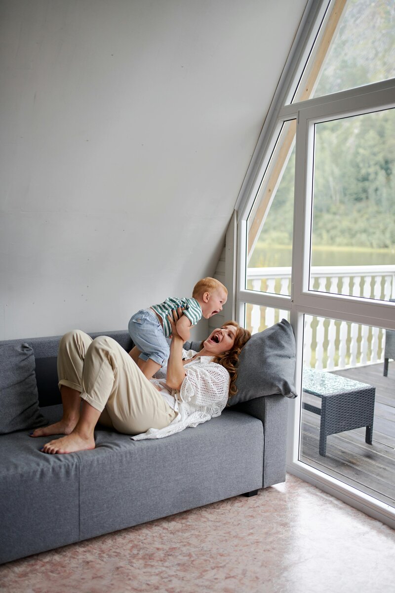 Mom playing happily with resting toddler