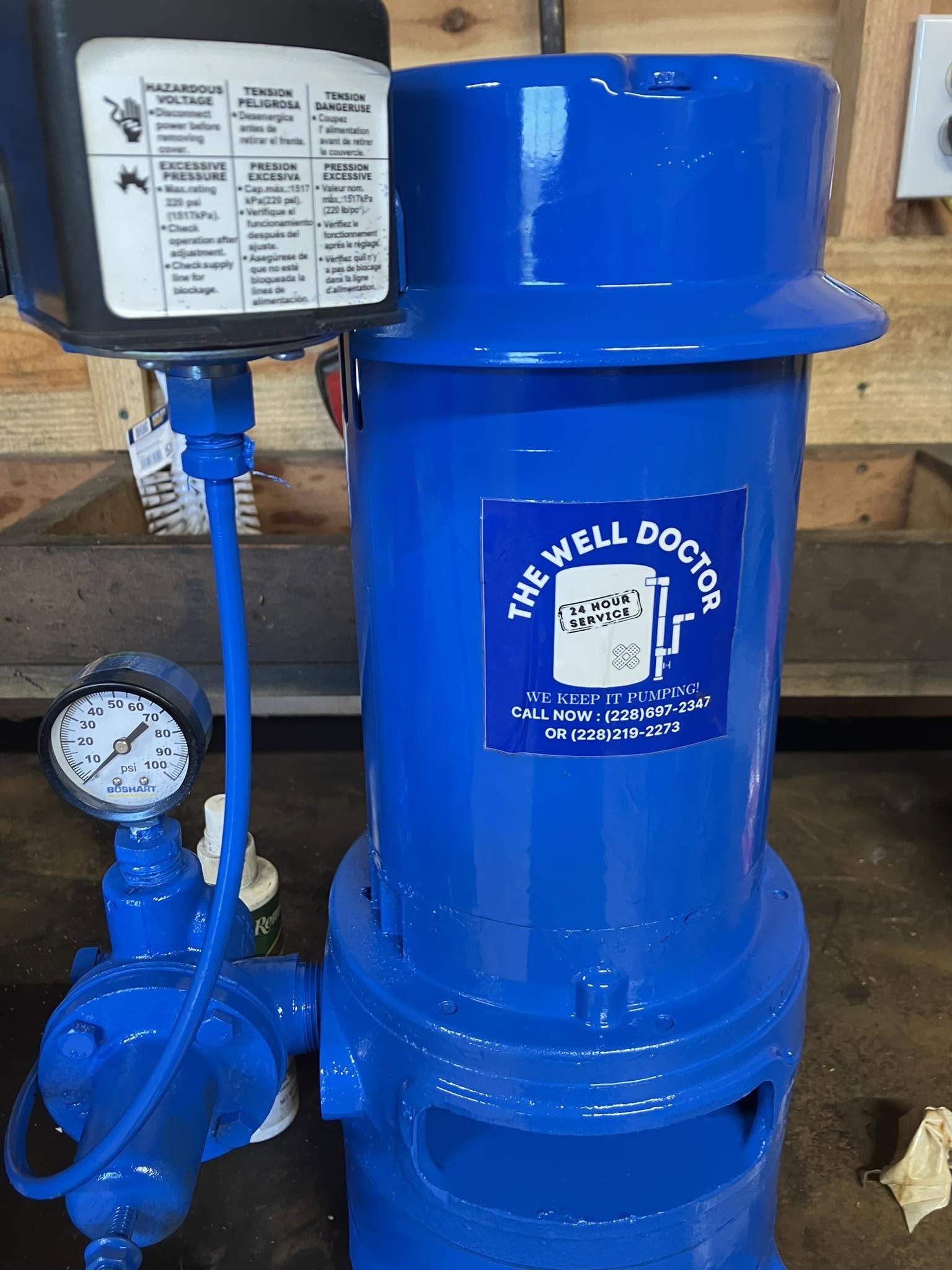 Clear up-close view of a freshly serviced royal blue Well Doctor pump with pressure gauge and switch