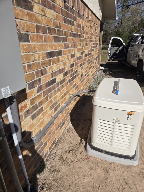 Standby generator on its pad with conduit run along the house