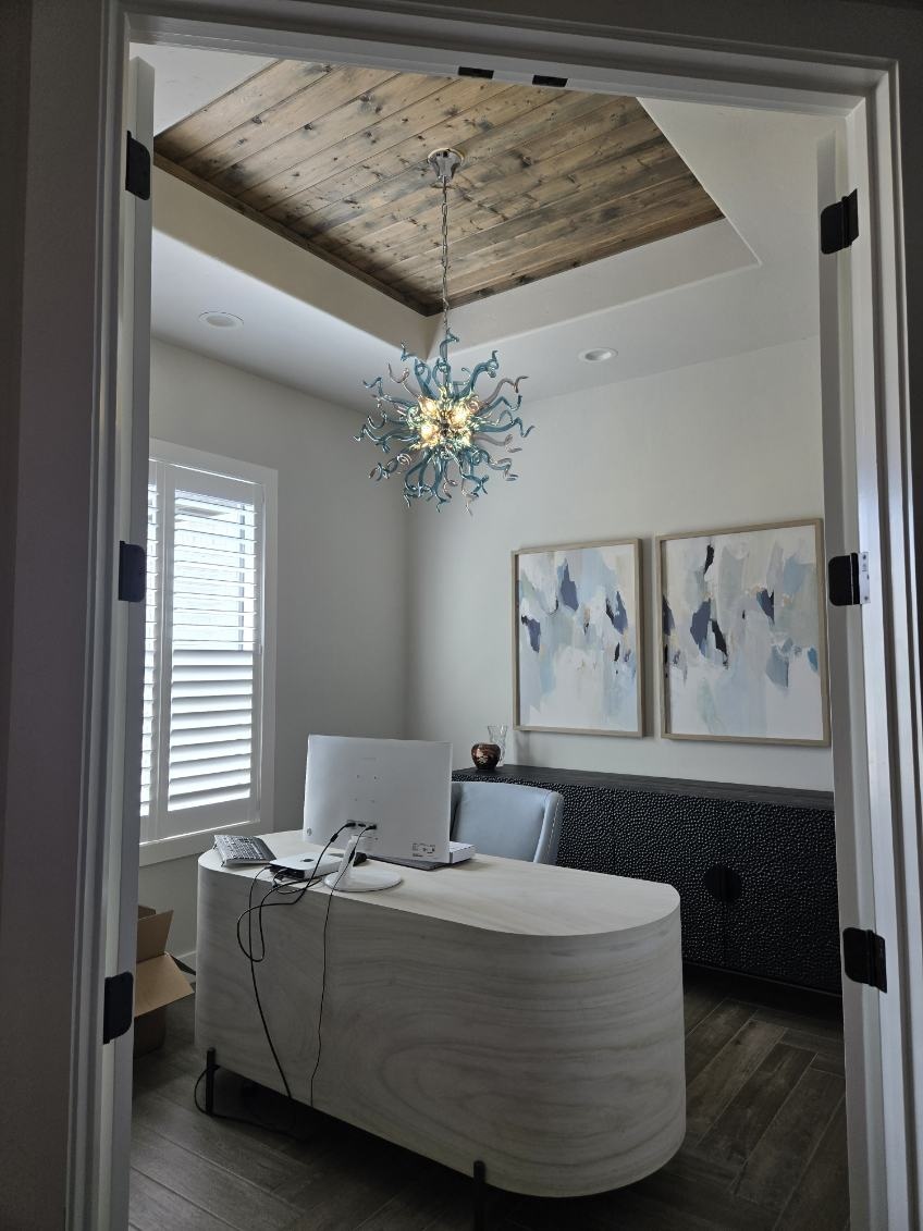 Blue glass chandelier and recessed lighting in a home office