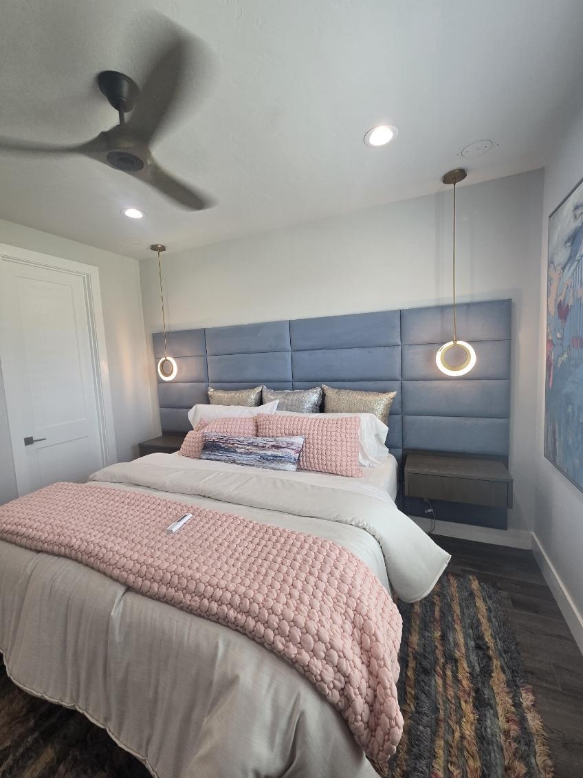 Bedroom with recessed lights, brass ring pendants and a ceiling fan installed by Rieger Electric