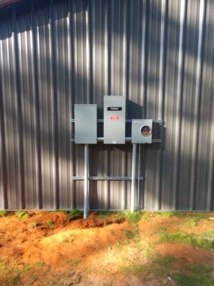 Electrical service equipment mounted on a metal shop building