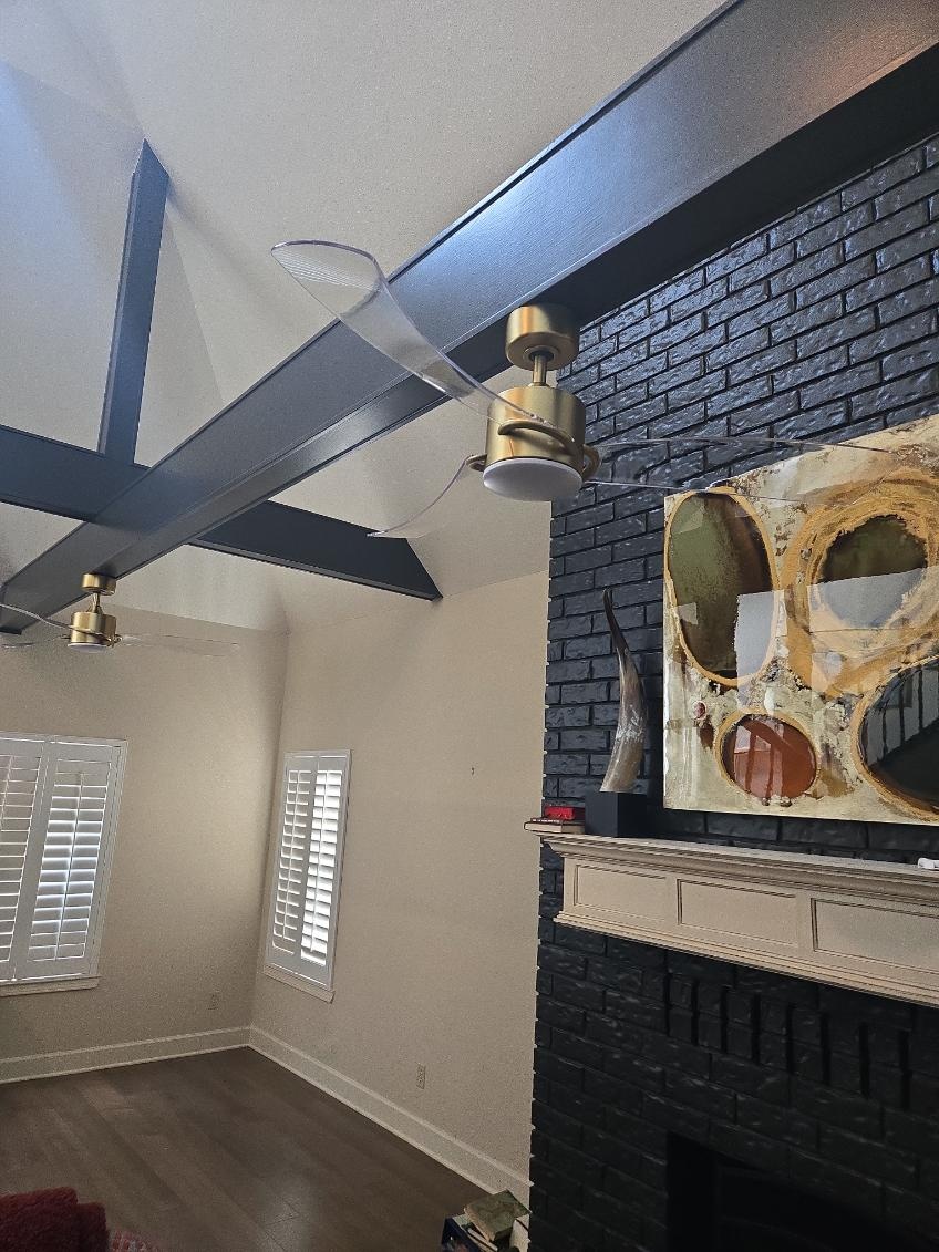 Two modern ceiling fans installed on a beamed vaulted ceiling