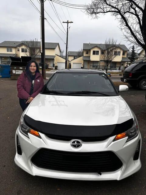 Happy customer standing with white car