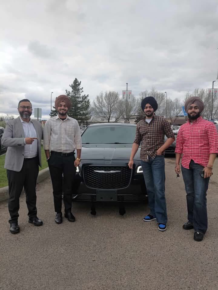 Clients standing with new black Chrysler sedan