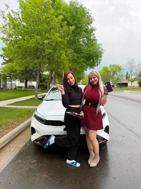 Two smiling clients with their white car