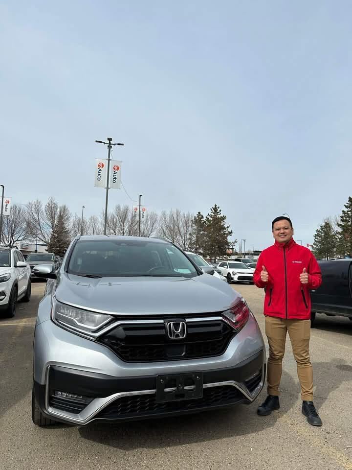 Client in red jacket giving thumbs up beside silver Honda SUV