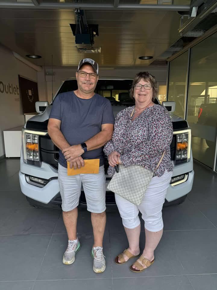Couple taking delivery of new white pickup truck