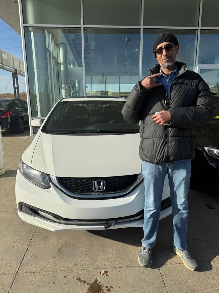 Proud owner standing next to white car