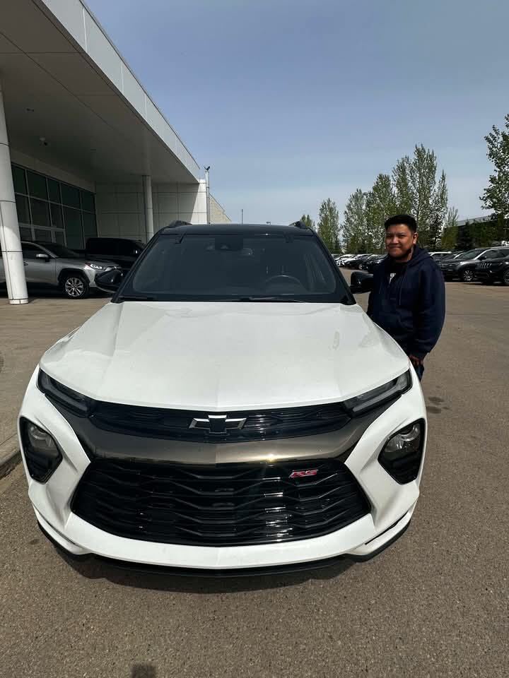 Smiling customer beside white Chevrolet crossover