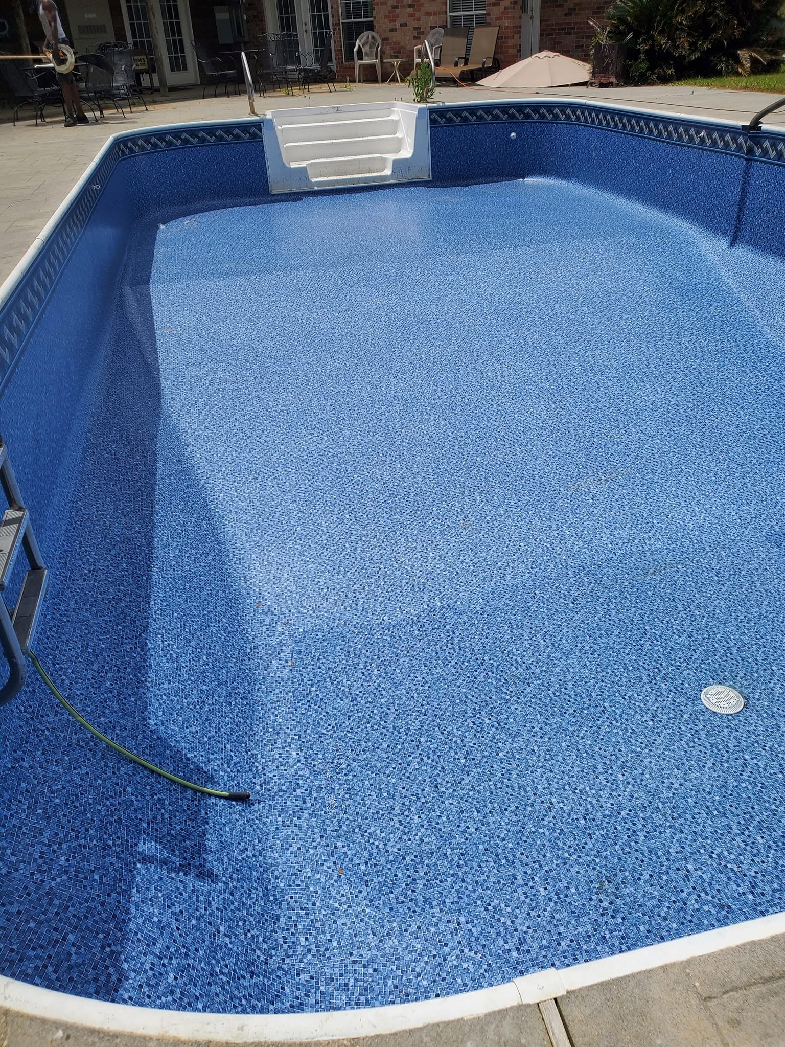 In-ground pool with newly installed fitted blue vinyl liner and stairs