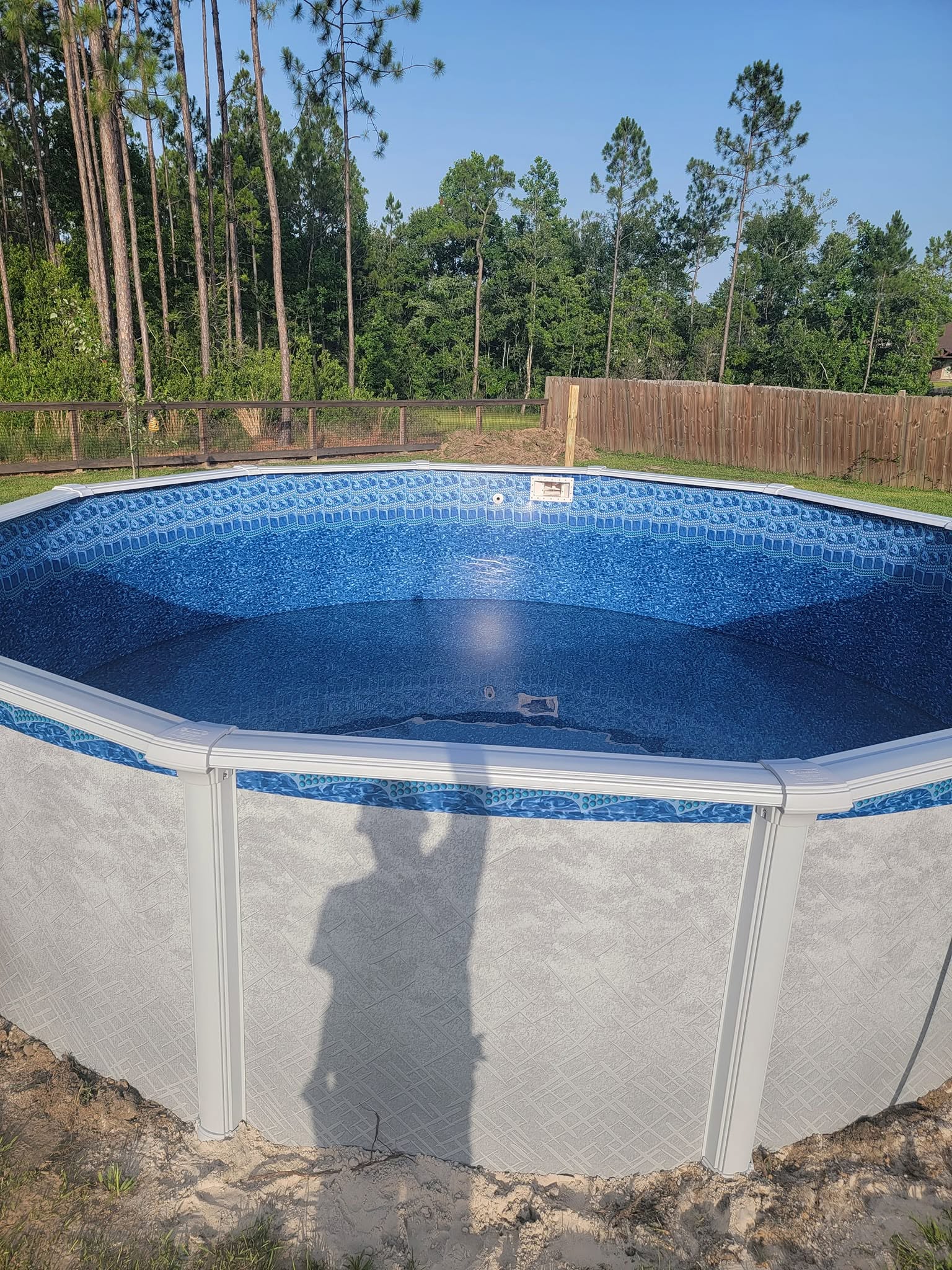 Round above-ground pool with blue liner and water