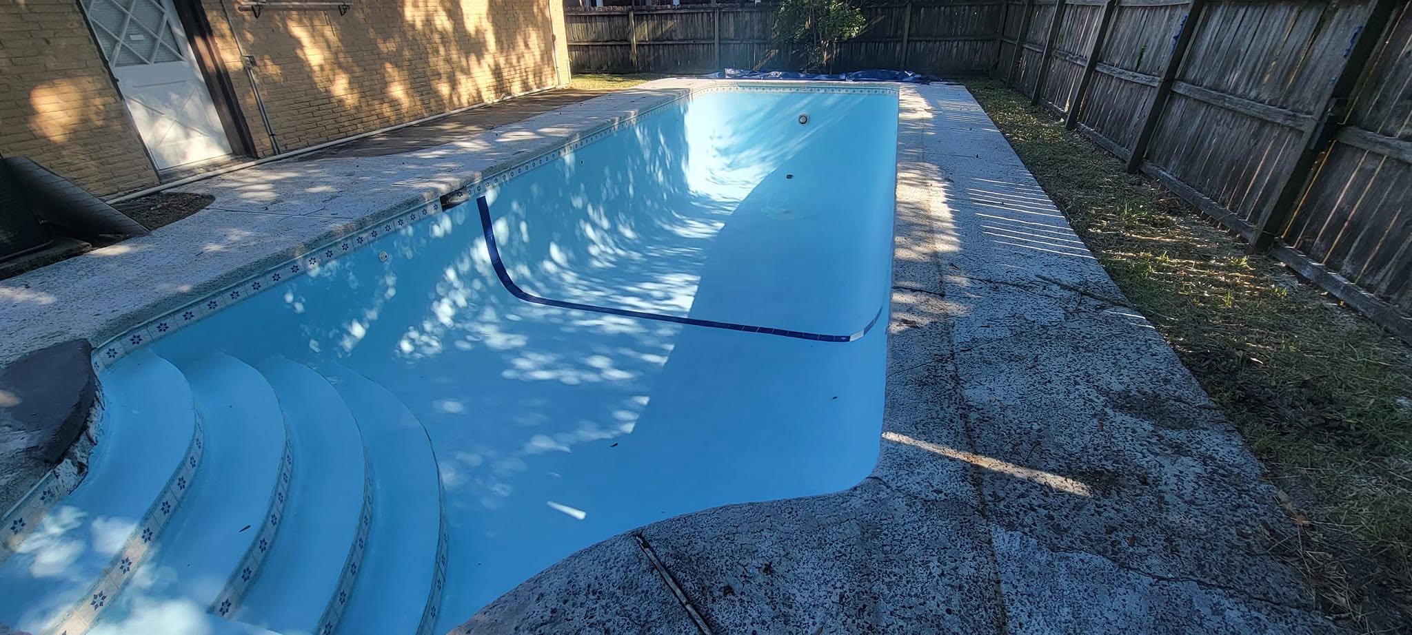 Drained pool basin after deep cleaning and power washing