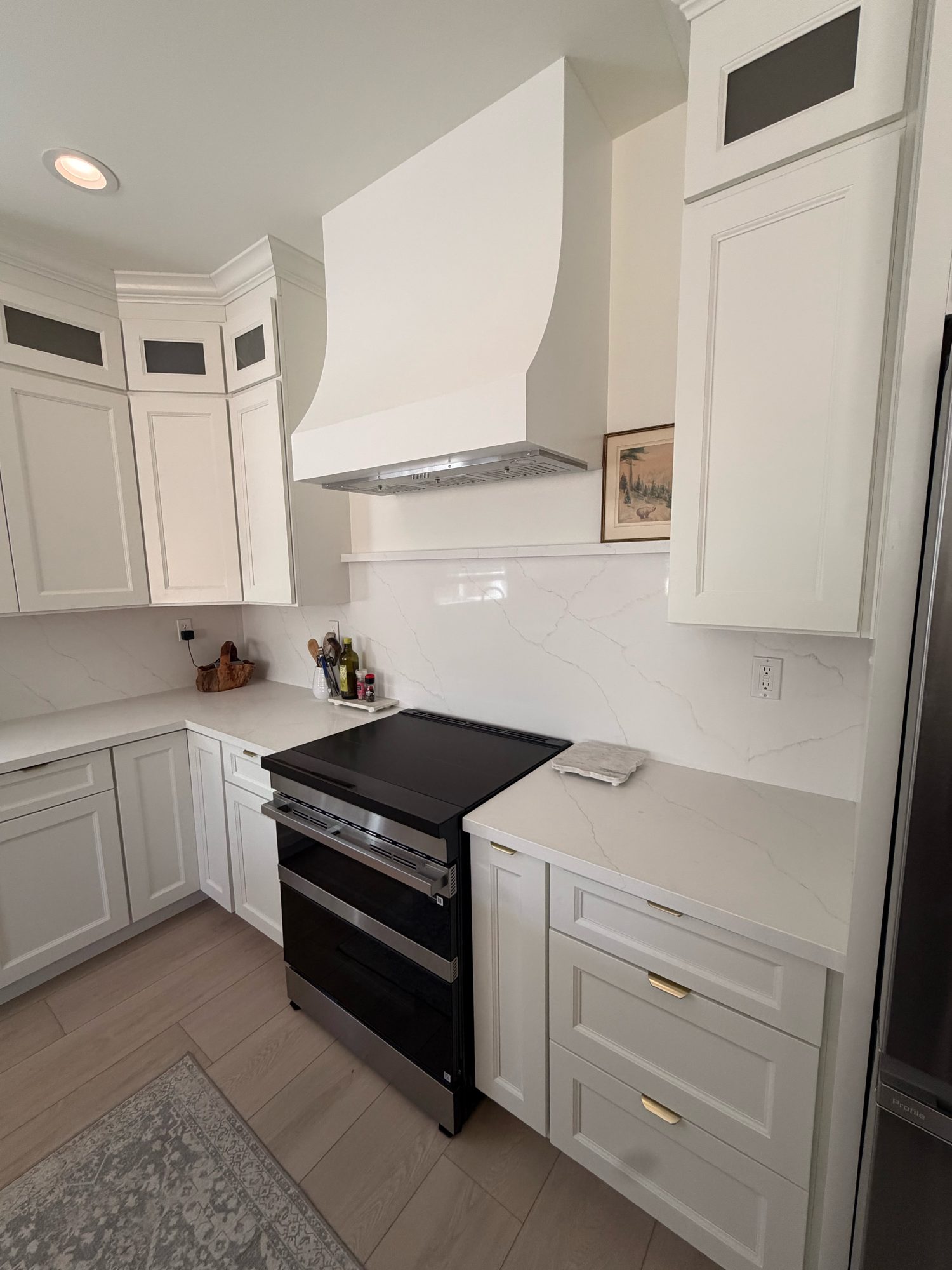 Quartz countertops with white shaker cabinets and range detail, Reno, NV