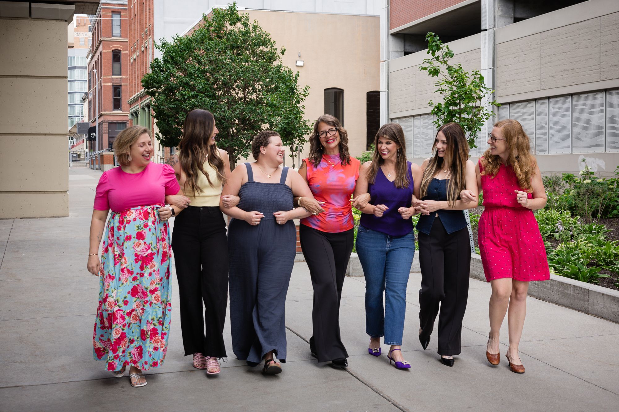 The Bosom Collective team walking arm in arm in downtown Lincoln.