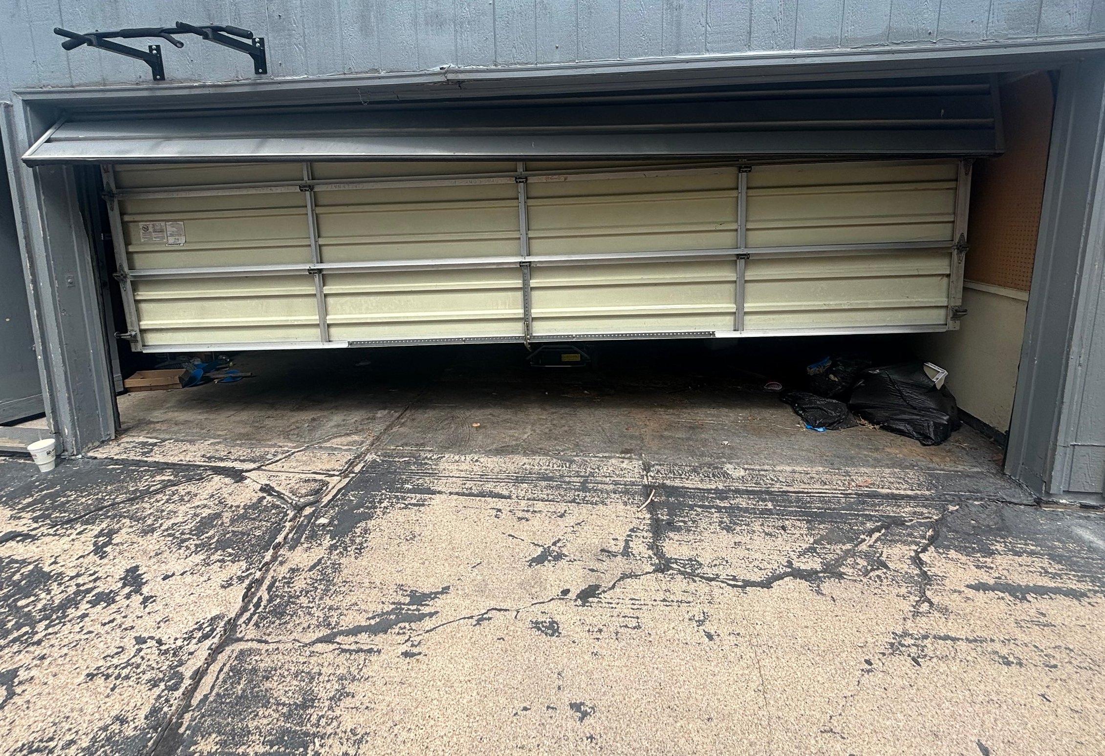 Before: damaged garage door hanging off its track