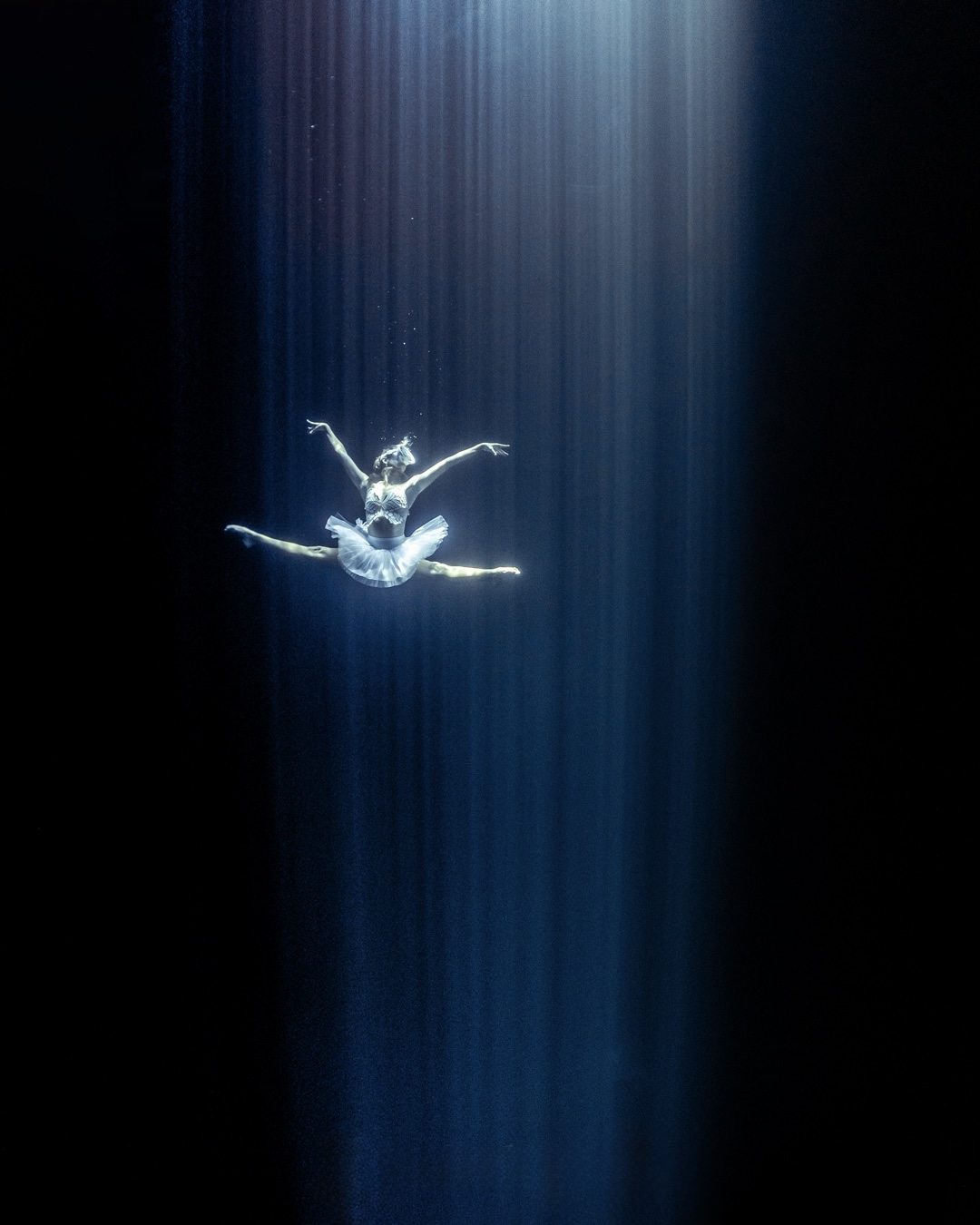 Kristina Makushenko performing an underwater ballet in a beam of light