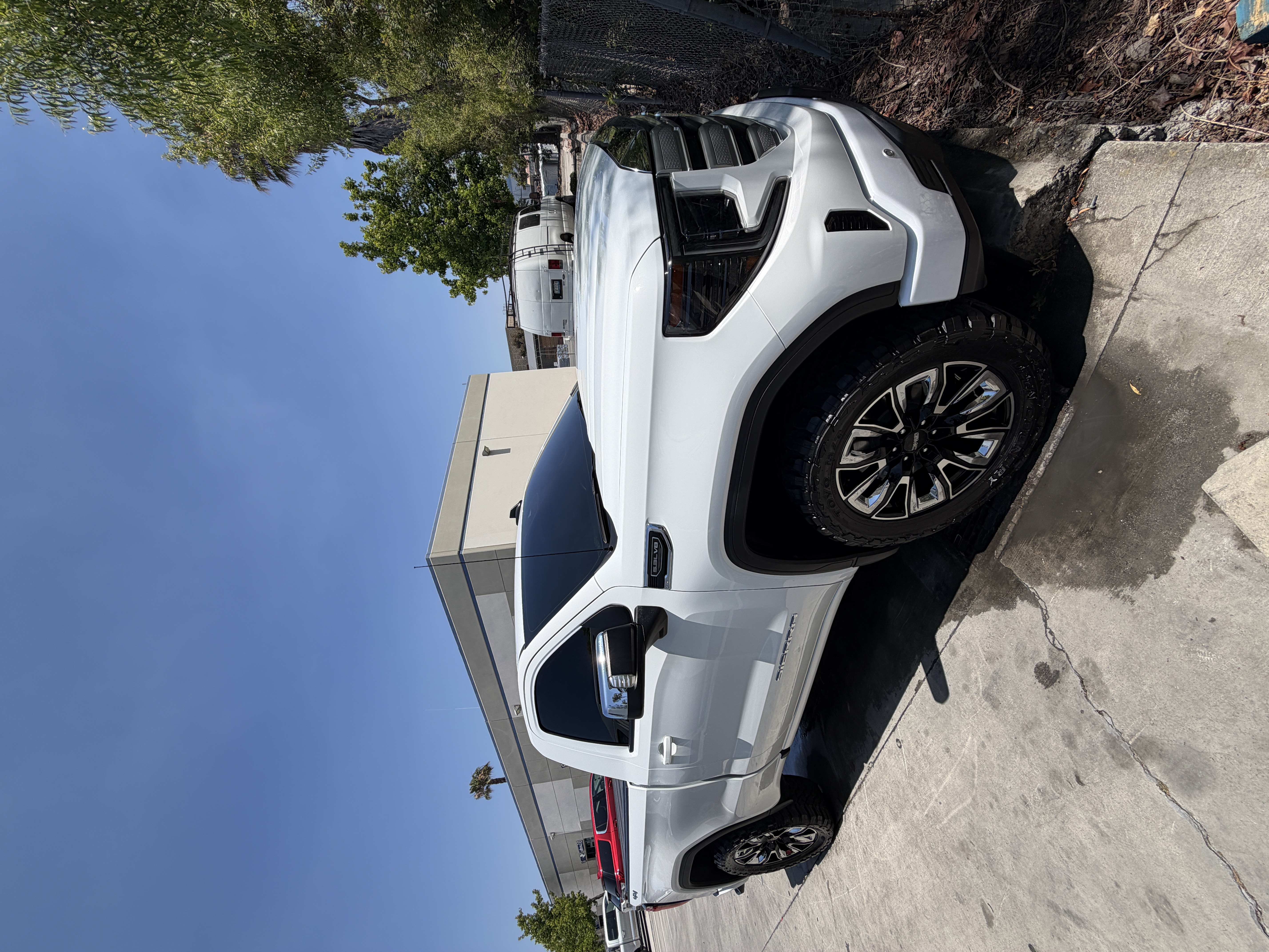 Freshly detailed white GMC Sierra truck gleaming in the sun