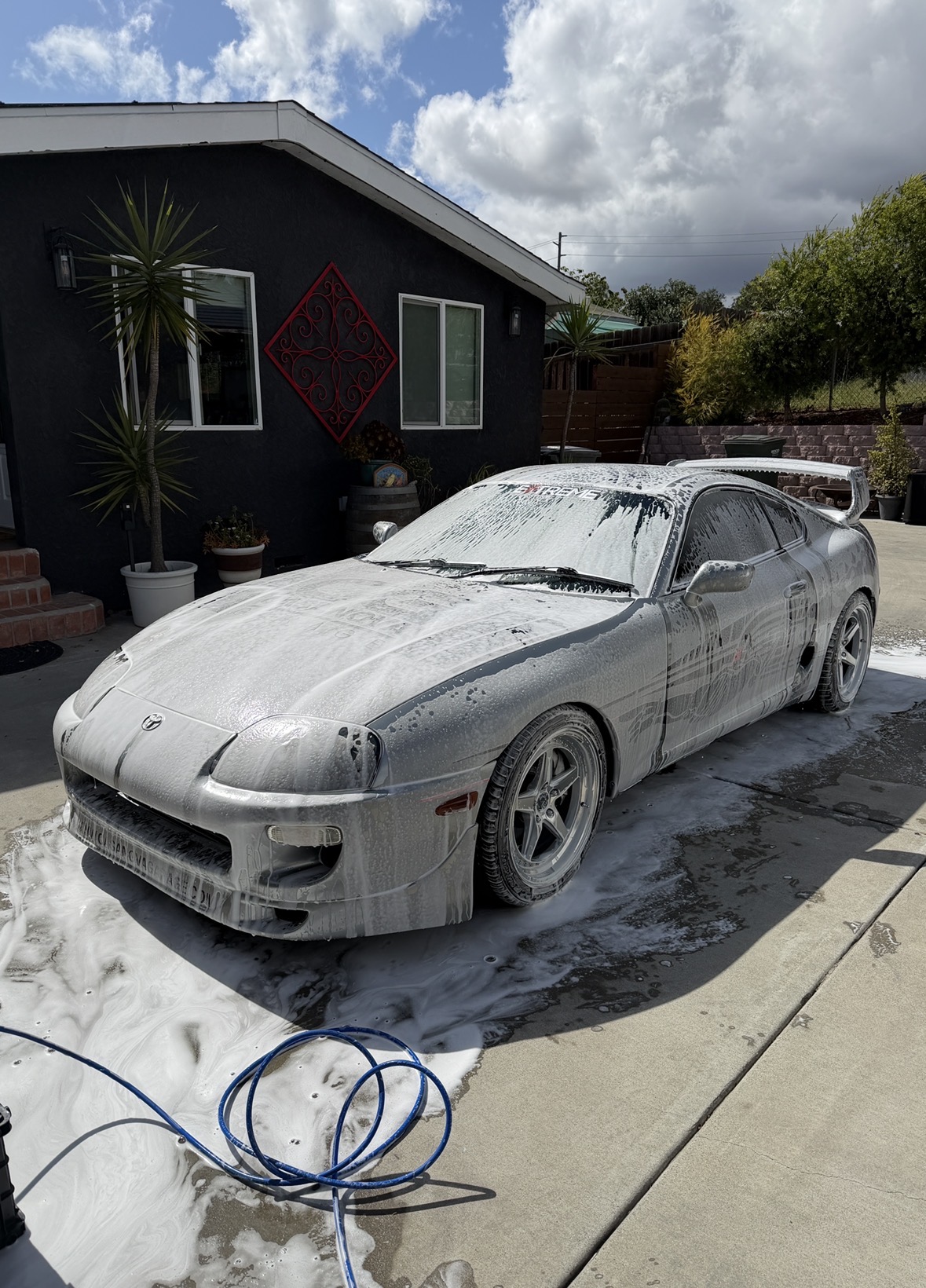 Toyota Supra covered in thick snow foam during mobile exterior wash