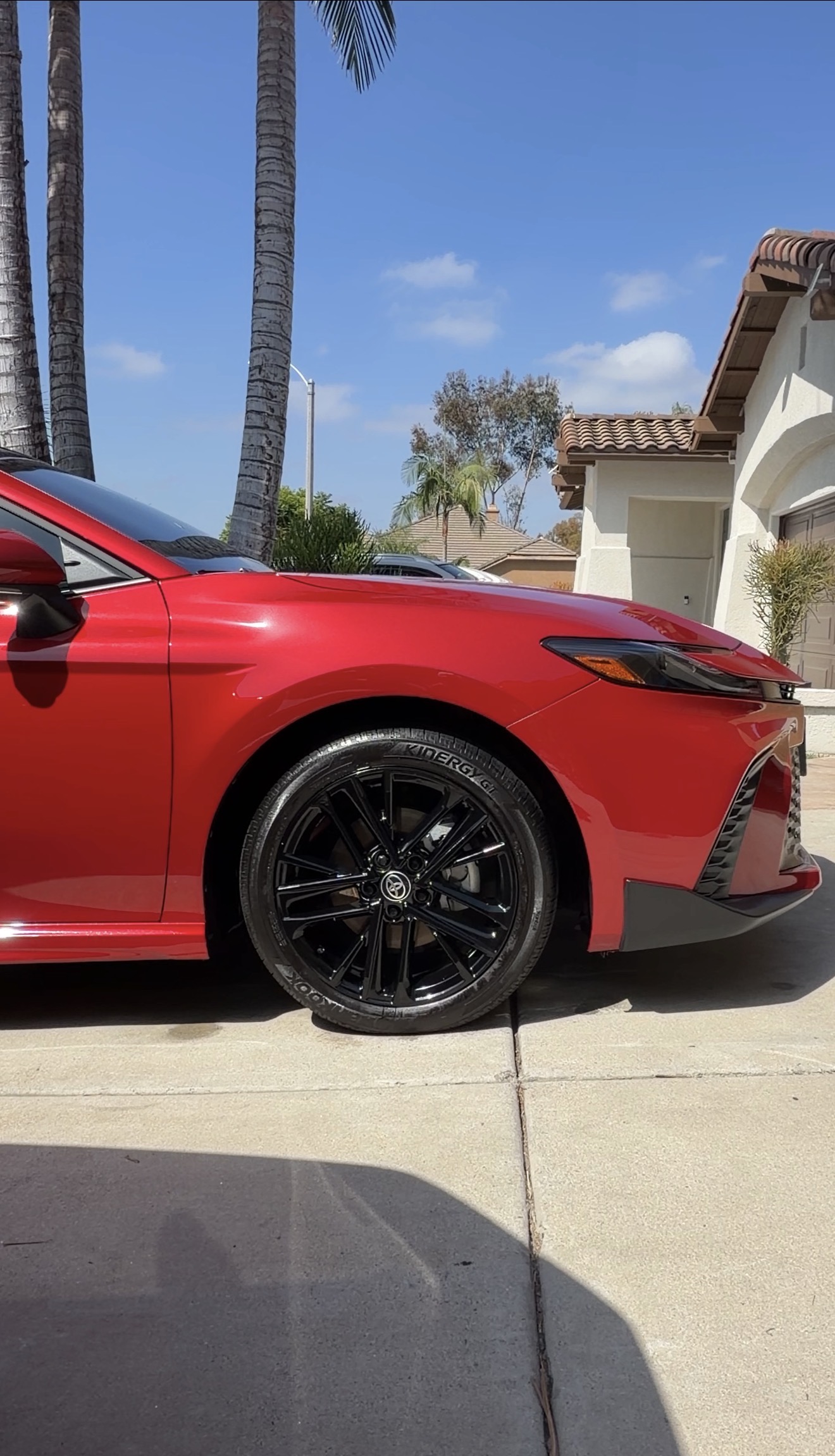 Deep gloss black wheel and dressed tire on red Toyota Camry