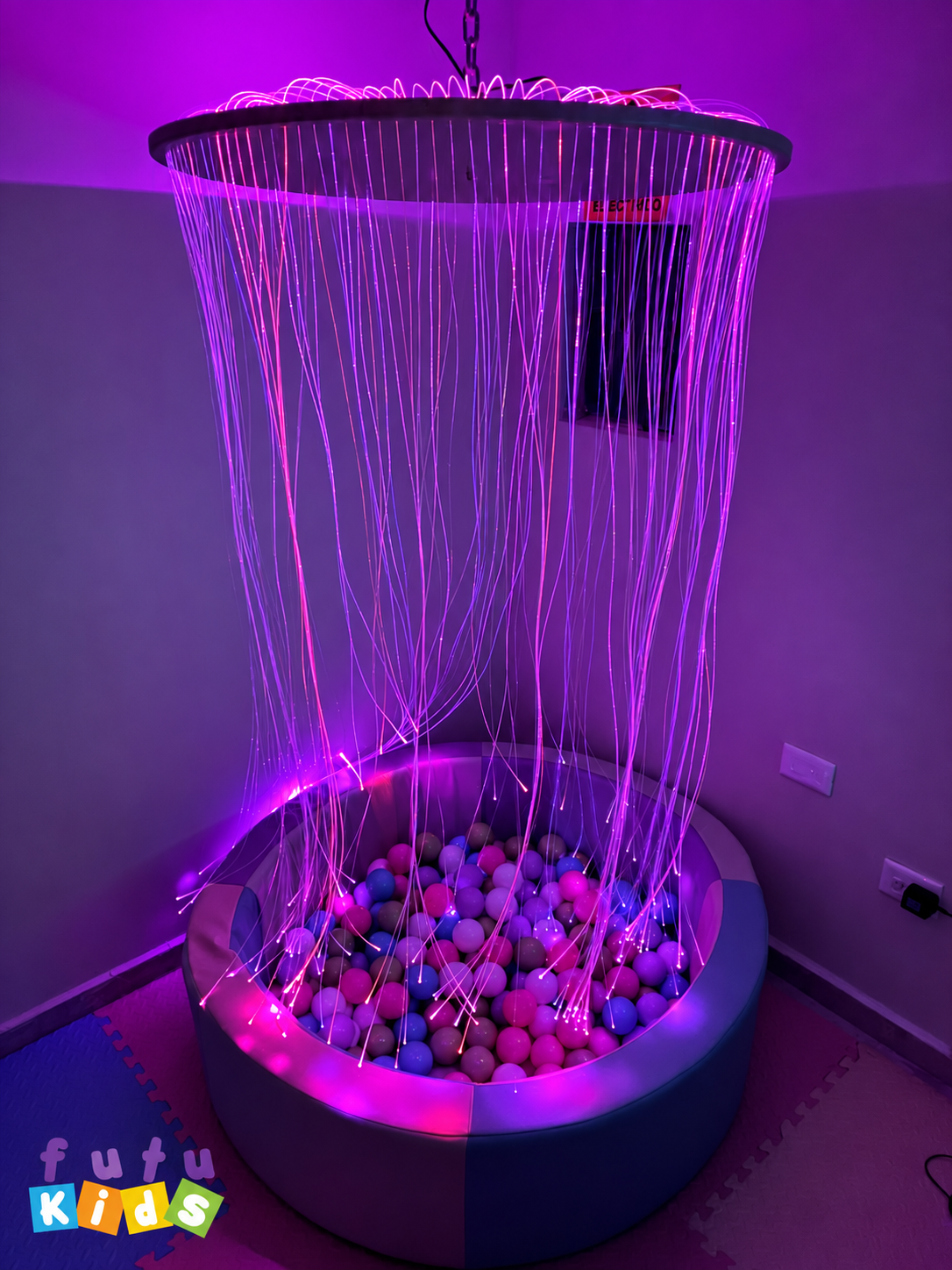 Sala de estimulación multisensorial en FutuKids Desarrollo Mágico con alberca de pelotas y fibra óptica con luces moradas