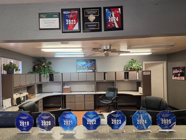 Best of Tempe collision repair awards display 2019-2025 at Campus Body Salon Ltd. front counter in Tempe, AZ