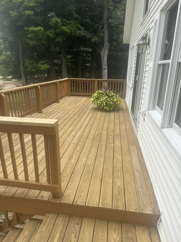Refinished wide deck planks and surrounding railings overlooking the lake