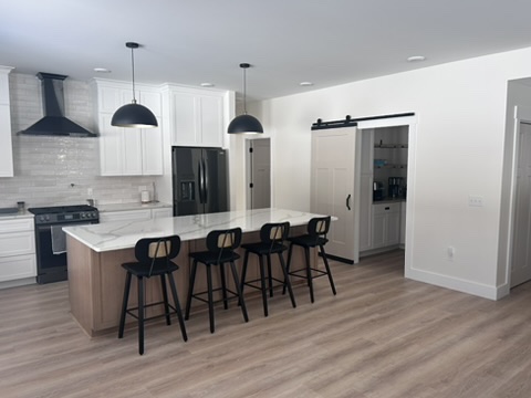 Open-concept modern kitchen with painted walls and barn door