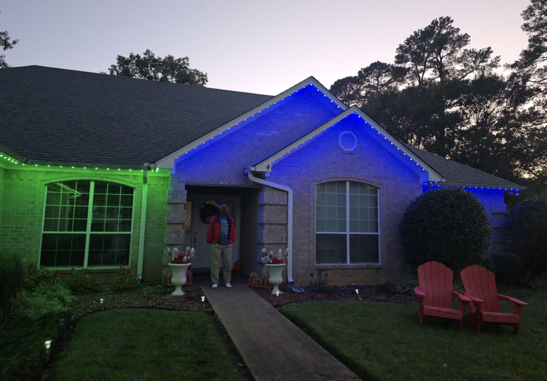 Completed permanent roofline lighting with bright blue and green illumination on Shreveport-area home