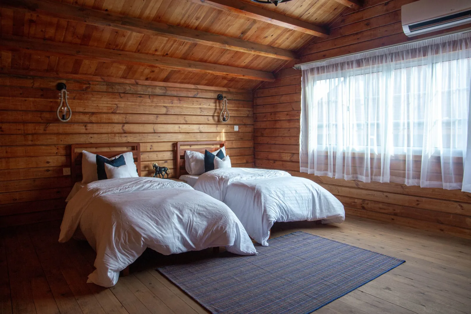 Cozy Vermont camp and cabin interior with clean beds and wooden beams