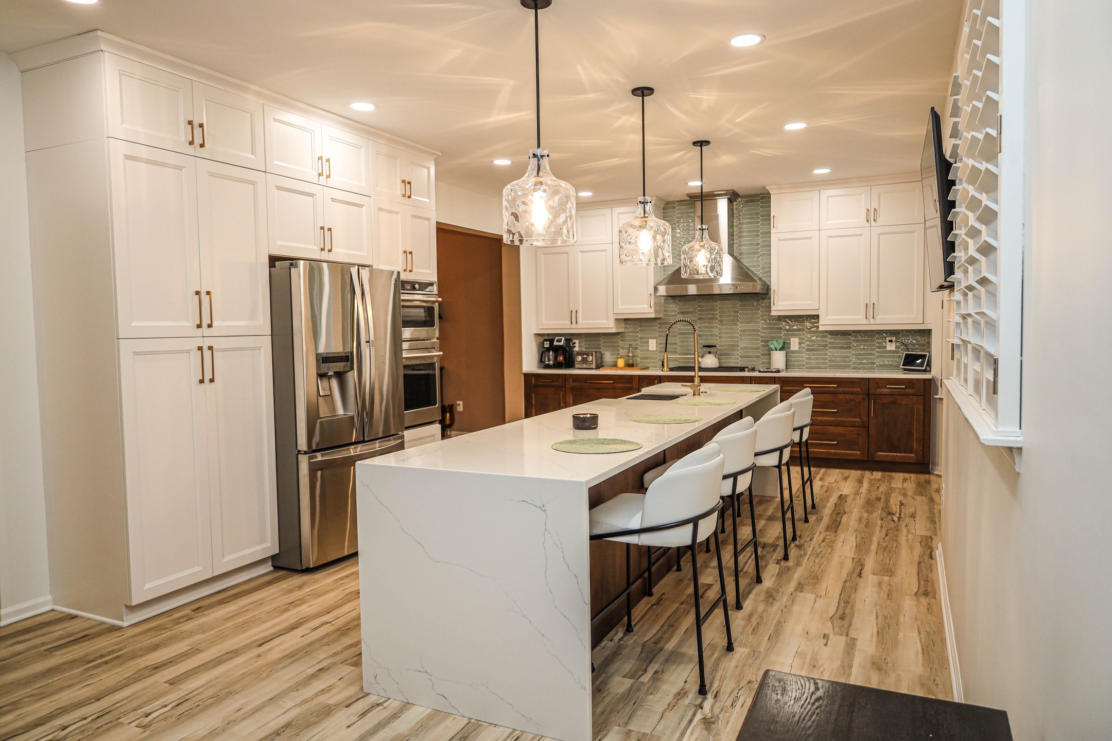 Open kitchen layout with island and pendant lighting by ProPeak Remodeling