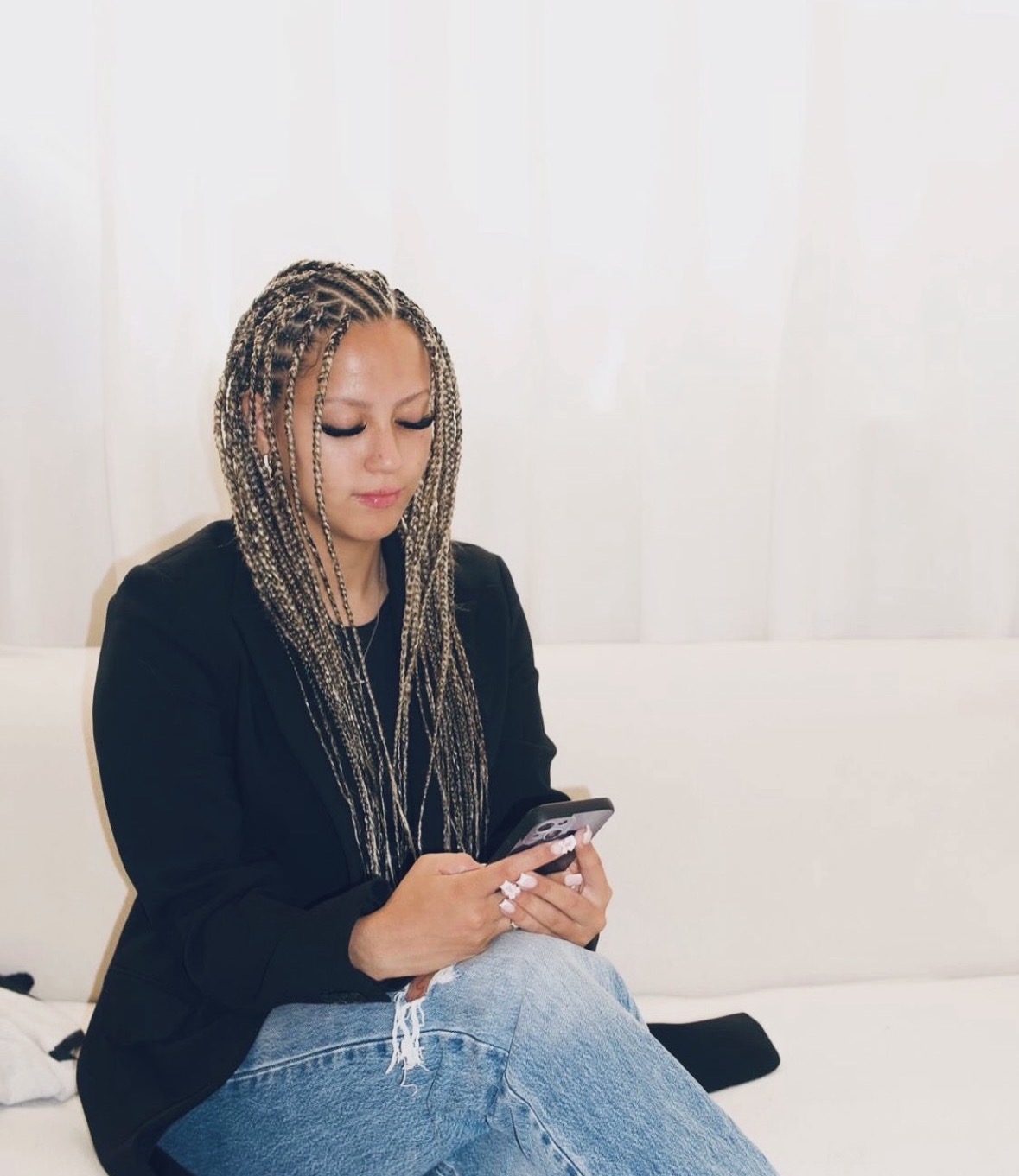 Braider checking client messages and bookings on her phone