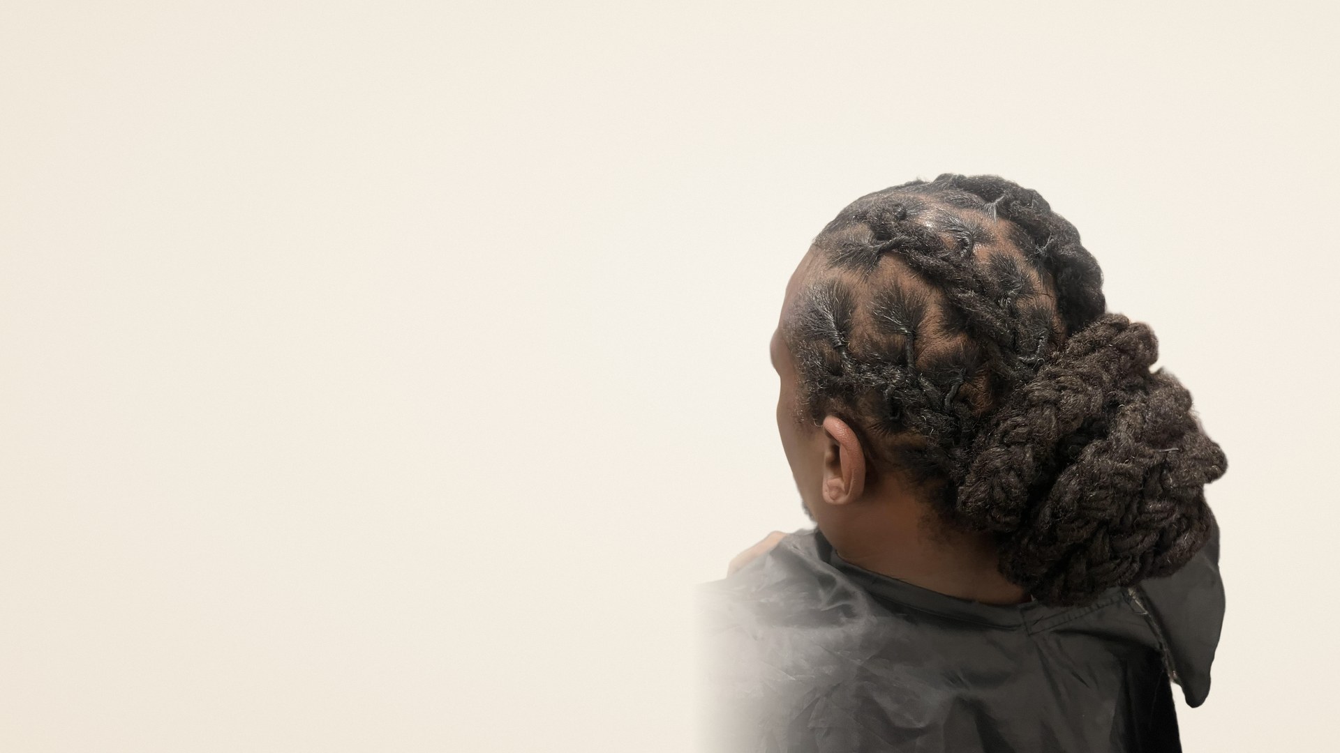 Detailed barrel-roll loc updo with low bun by Jennifer J at LOC & Curl Xpress ATL Salon in Decatur, GA