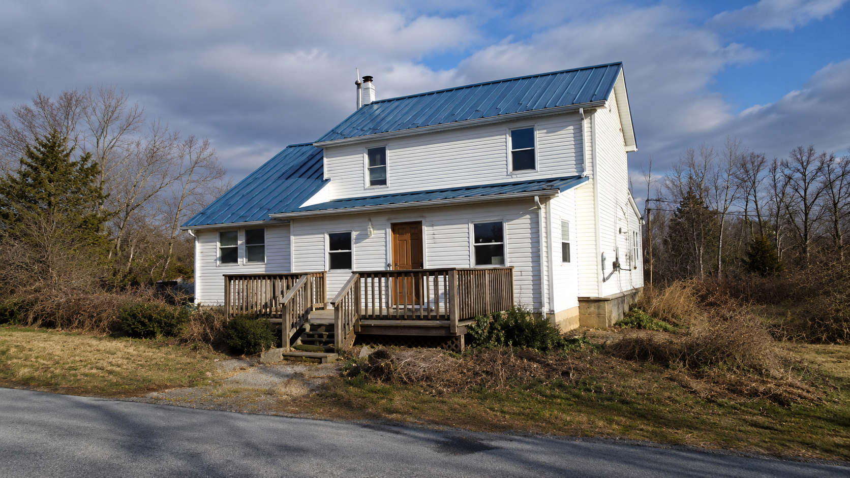 Front exterior of 9532 Keys Chapel Rd with white siding, standing seam roof, and country lawn