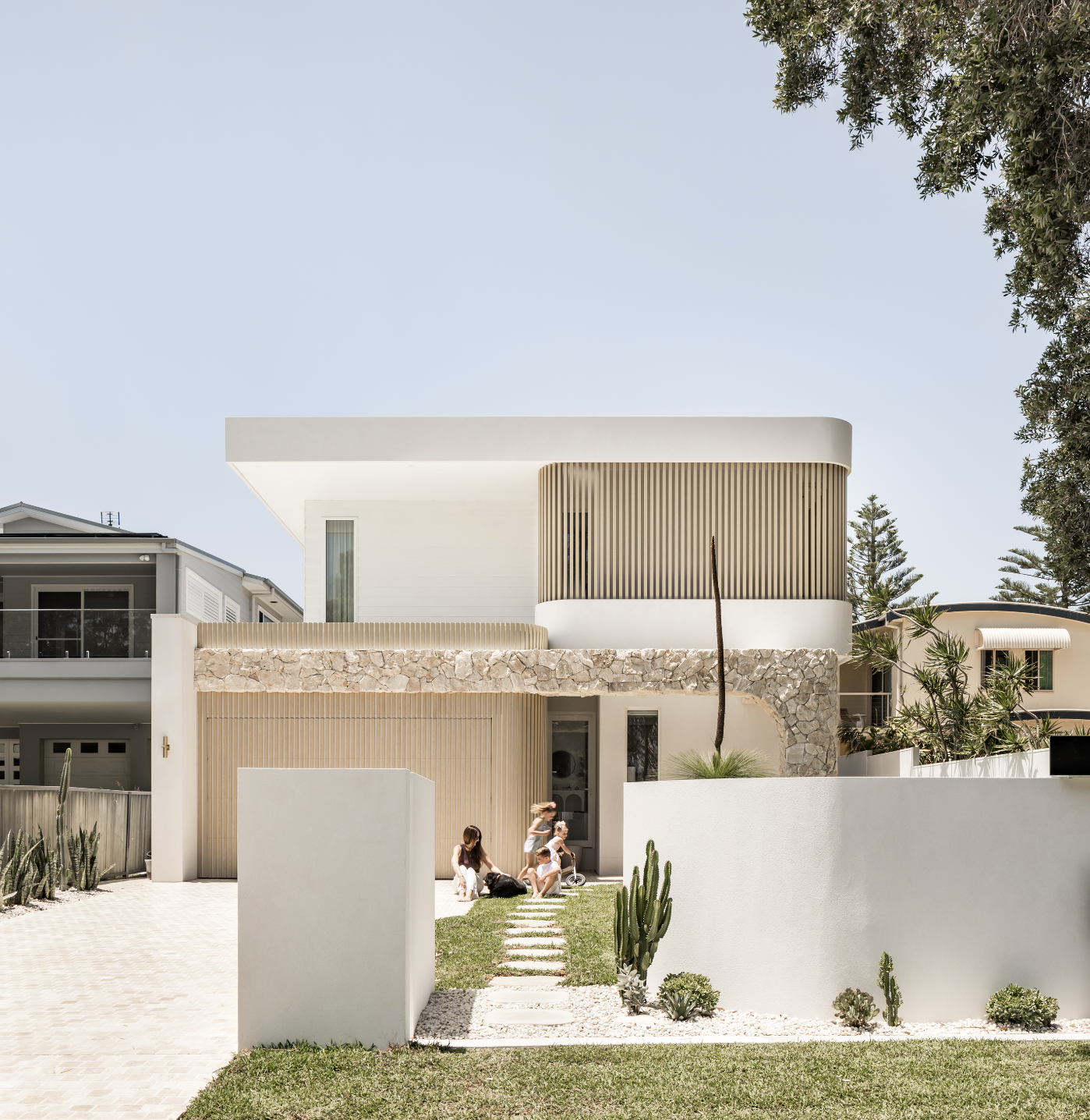 Architectural coastal home with custom timber screening and curved timber batten garage door