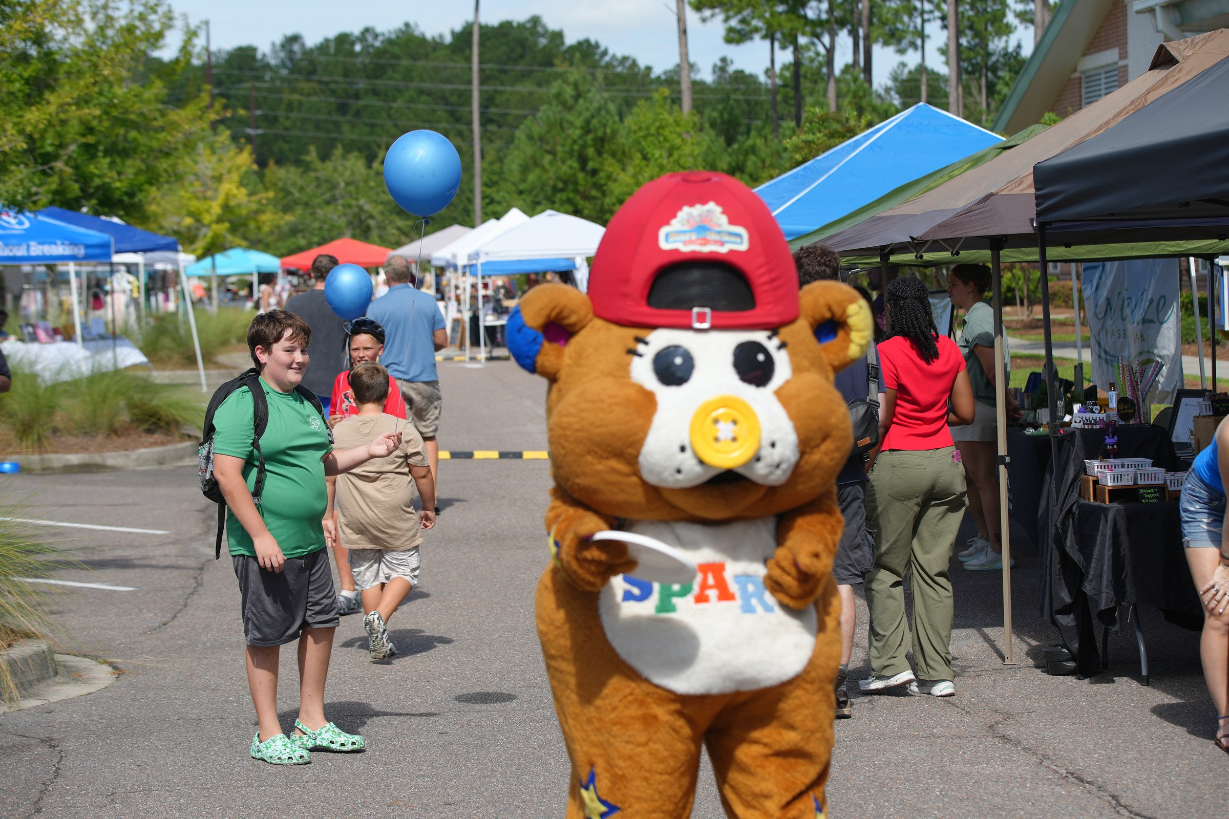 Summerville Destination Market mascot SPAR with kids and families at outdoor market booths