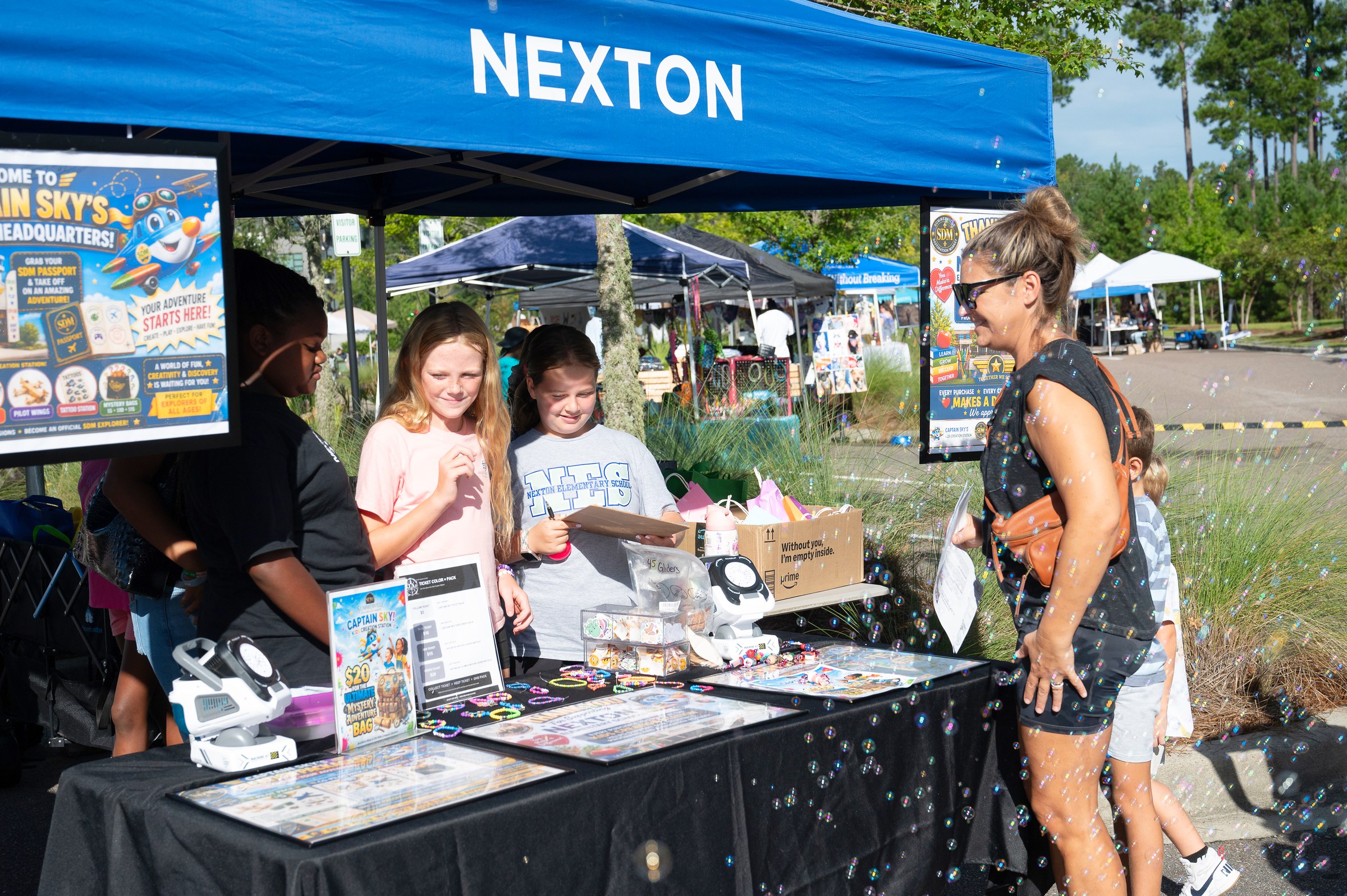 Captain Sky Kids Headquarters booth with young attendees, mystery bags, and outdoor activity