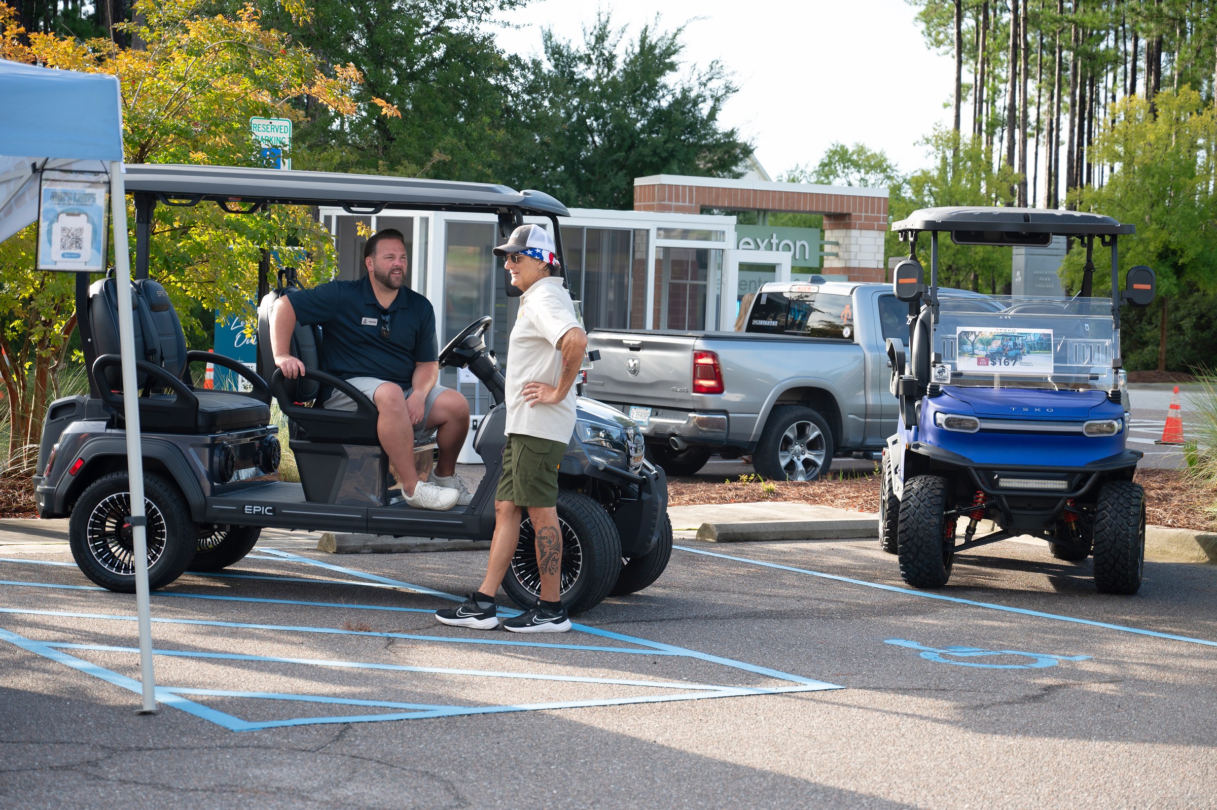 Attendees and local vendors conversing with custom golf carts at Nexton Elementary venue