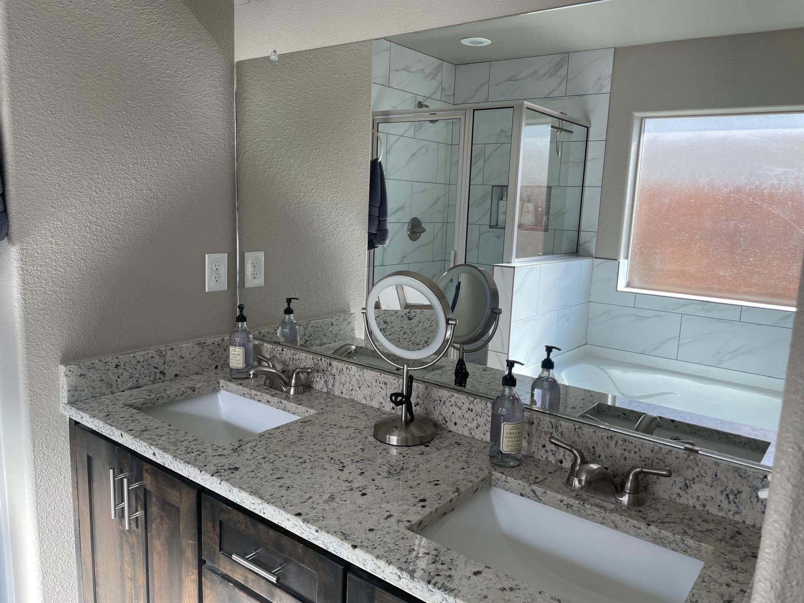 Spotless master bathroom double vanity and glass tile shower cleaned by Adri's Cleaning Services in Hobbs NM
