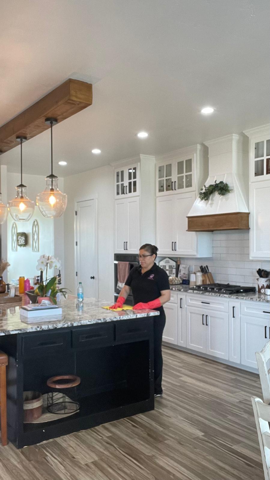 Adri's Cleaning Services cleaning specialist wiping down kitchen island countertops in Hobbs NM