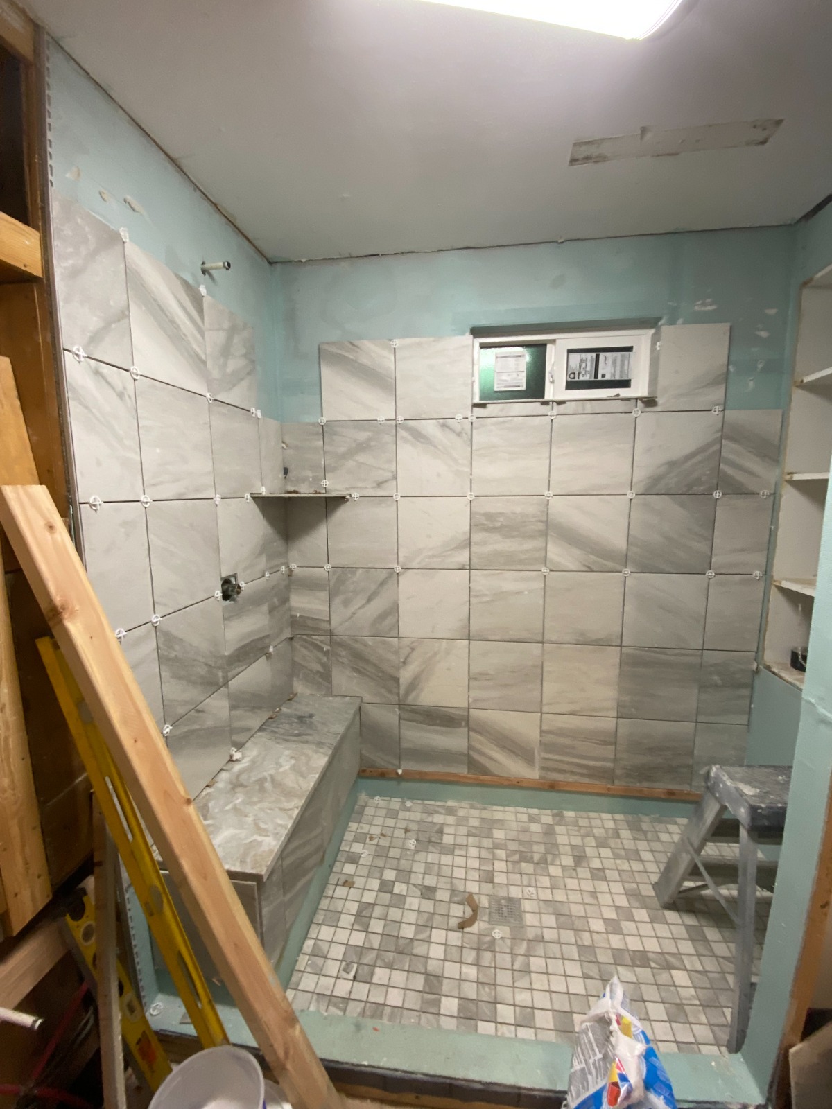 Custom marble shower tile setting and built-in bench by Rivercrest Home Services LLC in Wenatchee WA