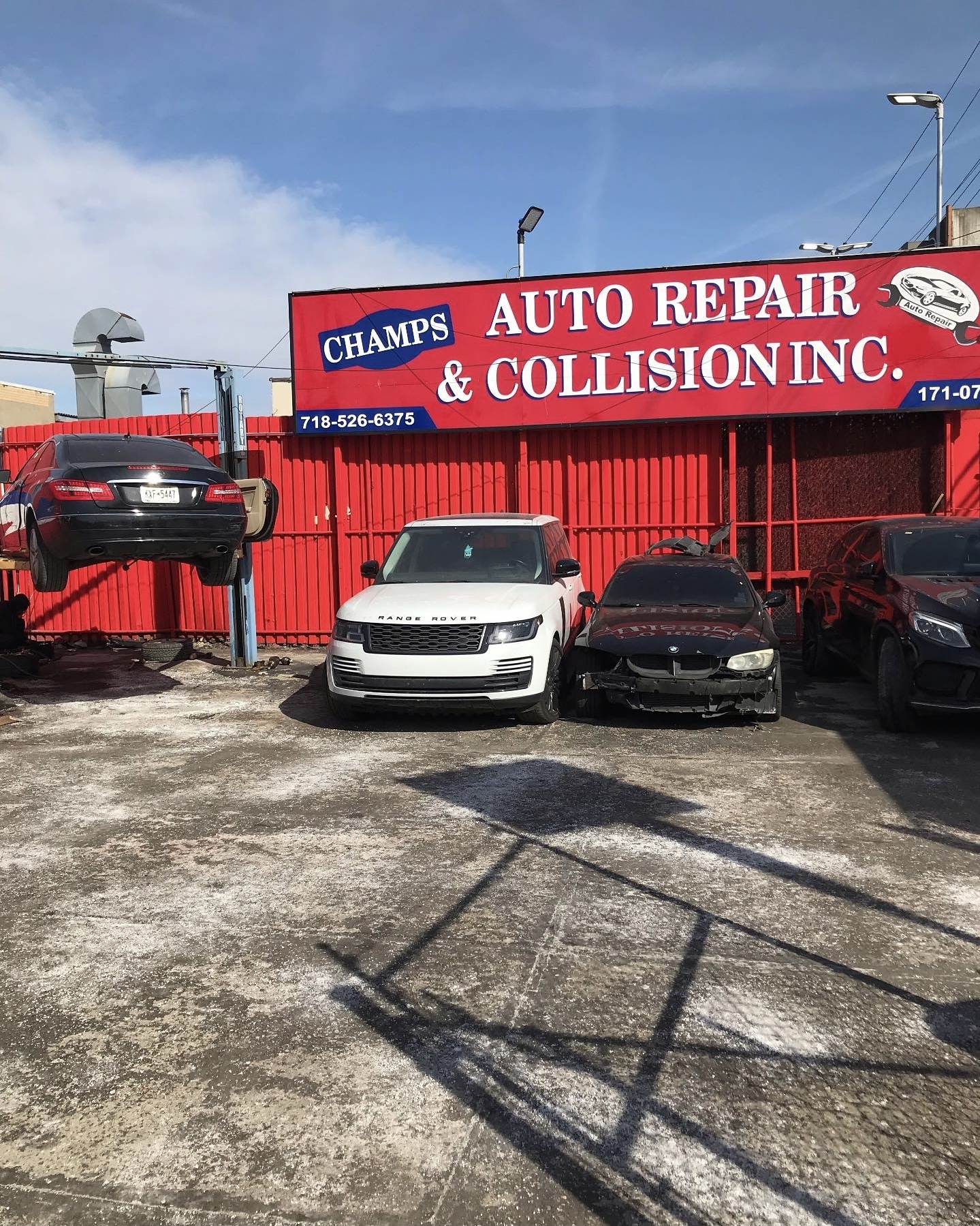 Outdoor vehicle lift, Range Rover and collision repairs at Champs Auto