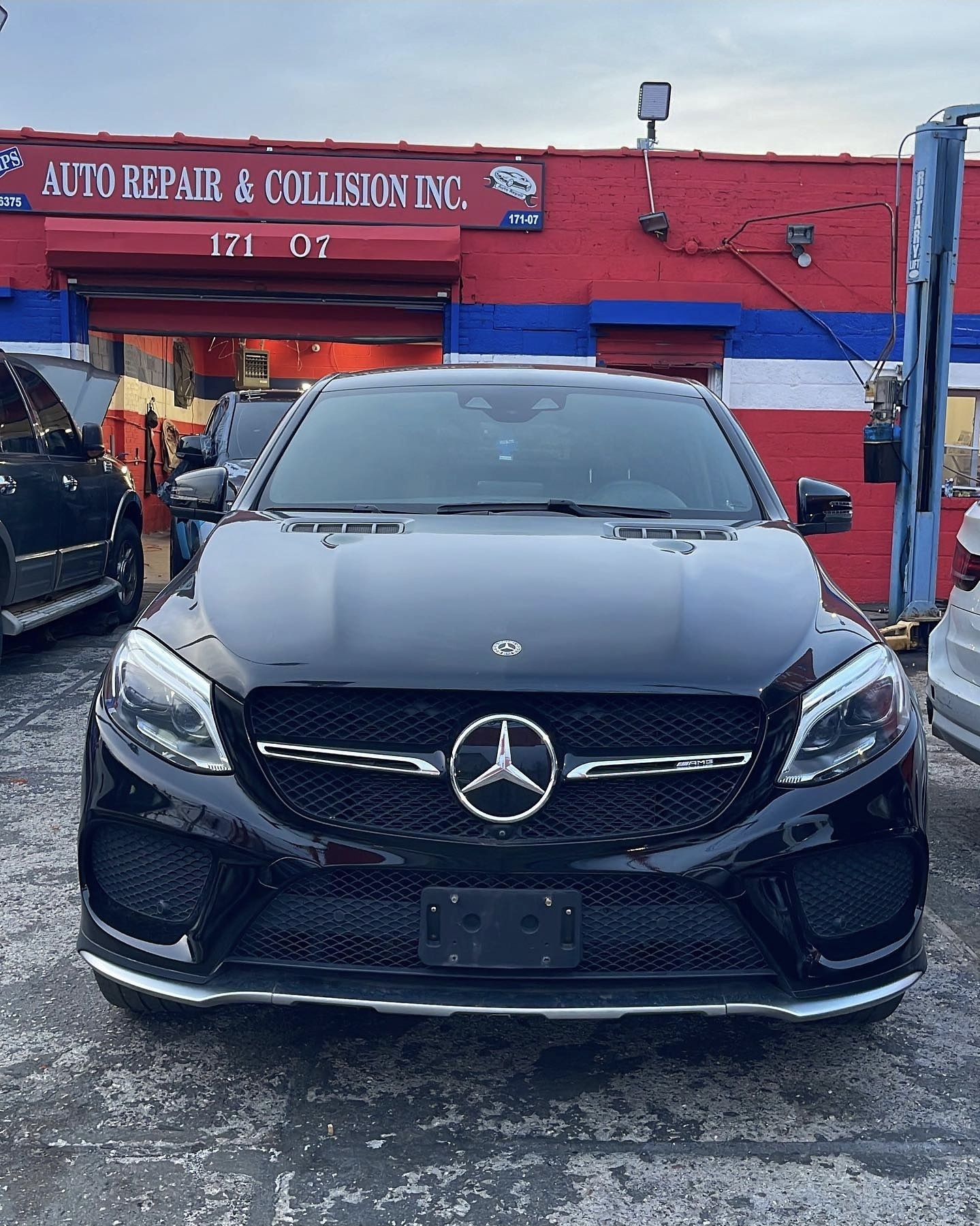 Completed Mercedes-Benz AMG repair in front of Champs Auto service bays