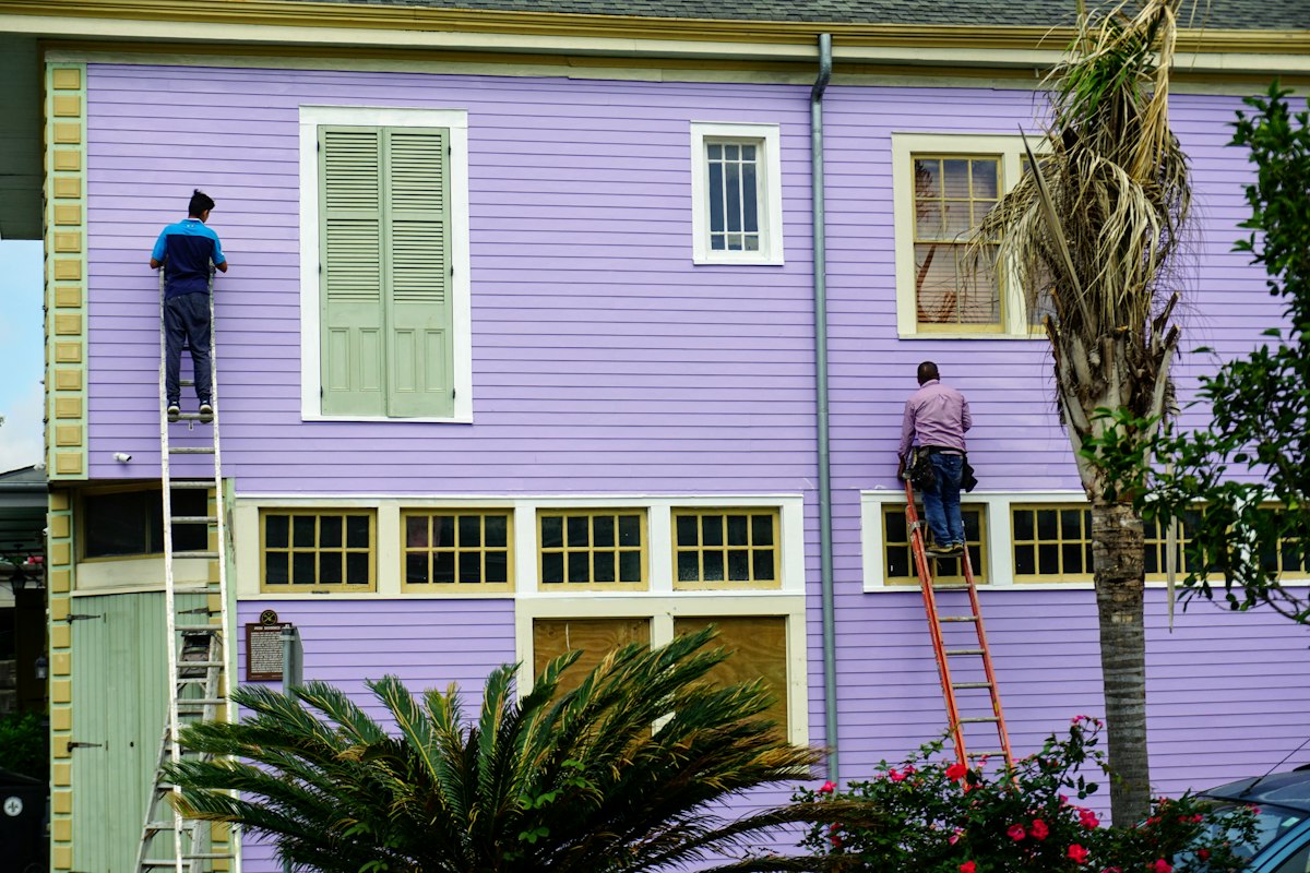 Exterior house painters working from ladders on a Tampa FL home